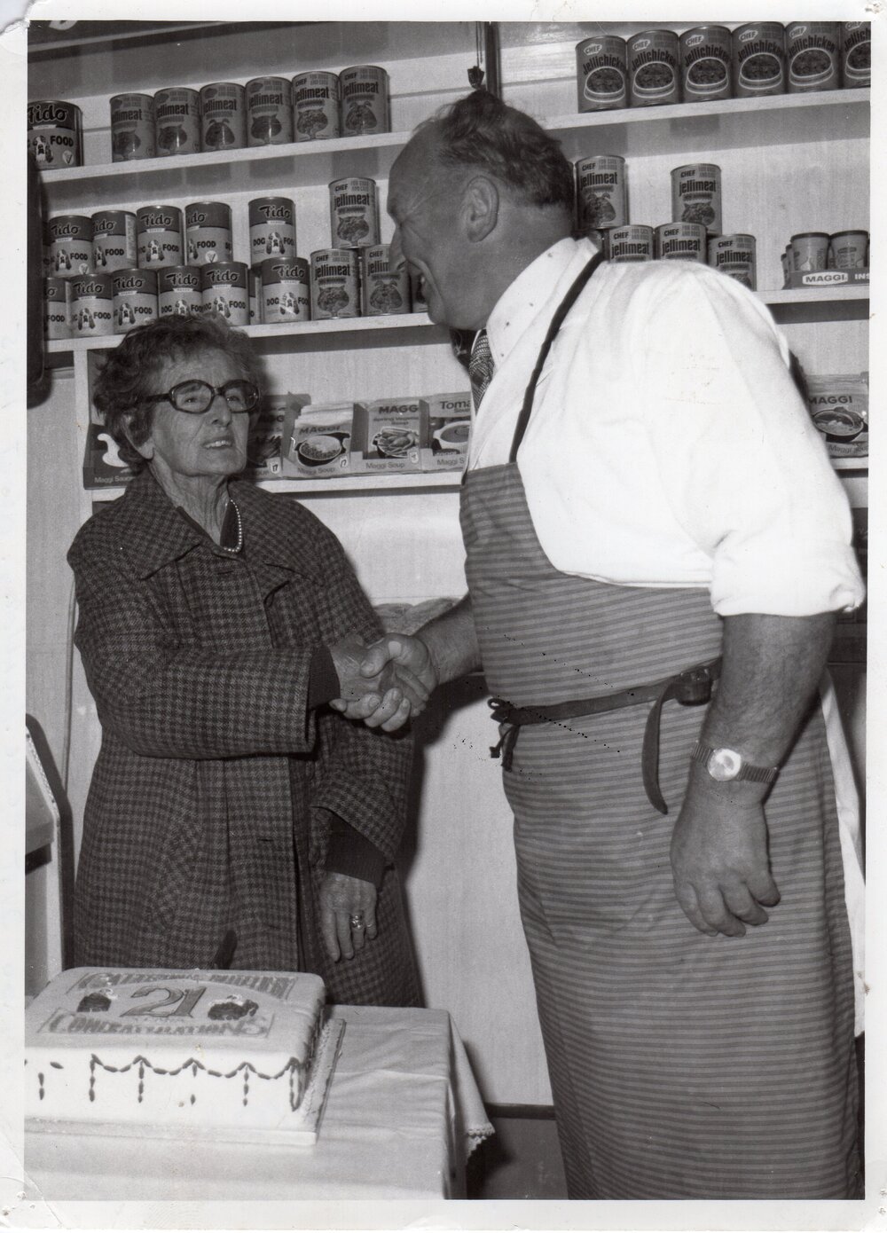 A. Cattermole Butcher and Mrs Britsow with the business's 21st celebration cake, Kaiapoi