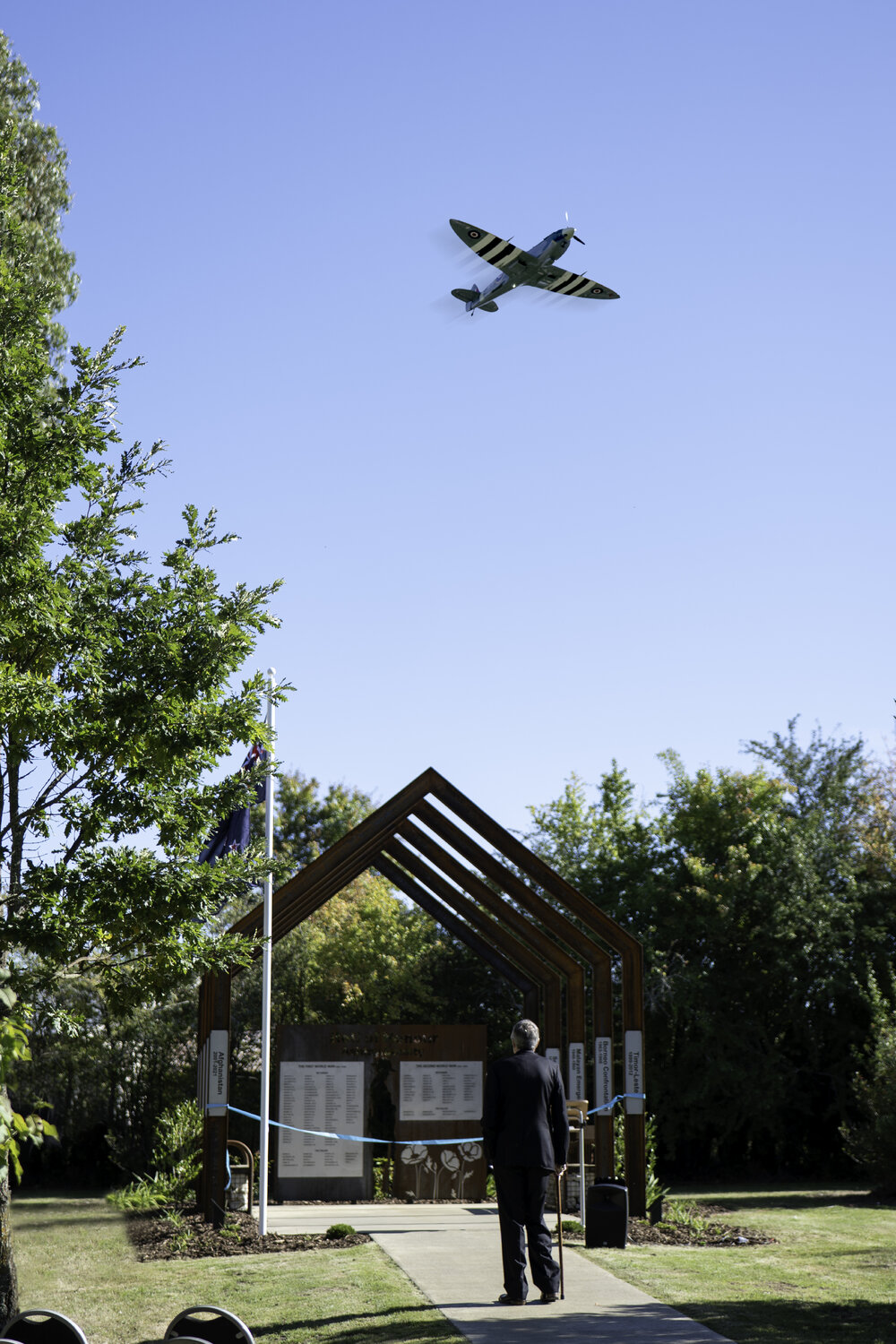 A replica Spitfire flies over the unveiling of the Loburn War Memorial, 2025