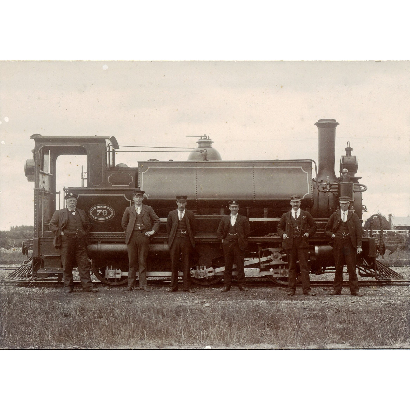 An ‘F’ class railway locomotive no.79 probably ‘The Punt’ at Bennetts with New Zealand Railway staff including the engine driver George Stirling. Date 1906/7